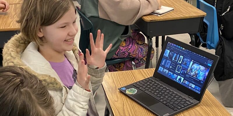 A smiling student browsing Comics Plus titles on a Chromebook